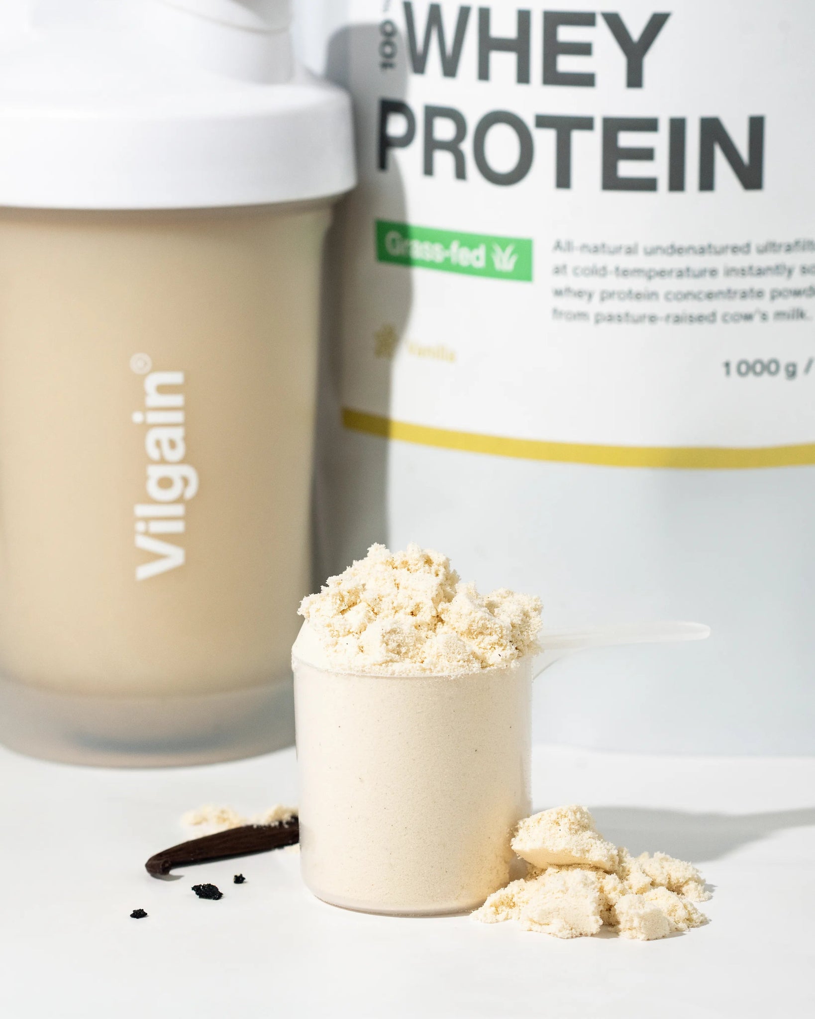 Grass-Fed Whey Protein powder in scoop with Vilgain shaker, highlighting premium quality protein blend.