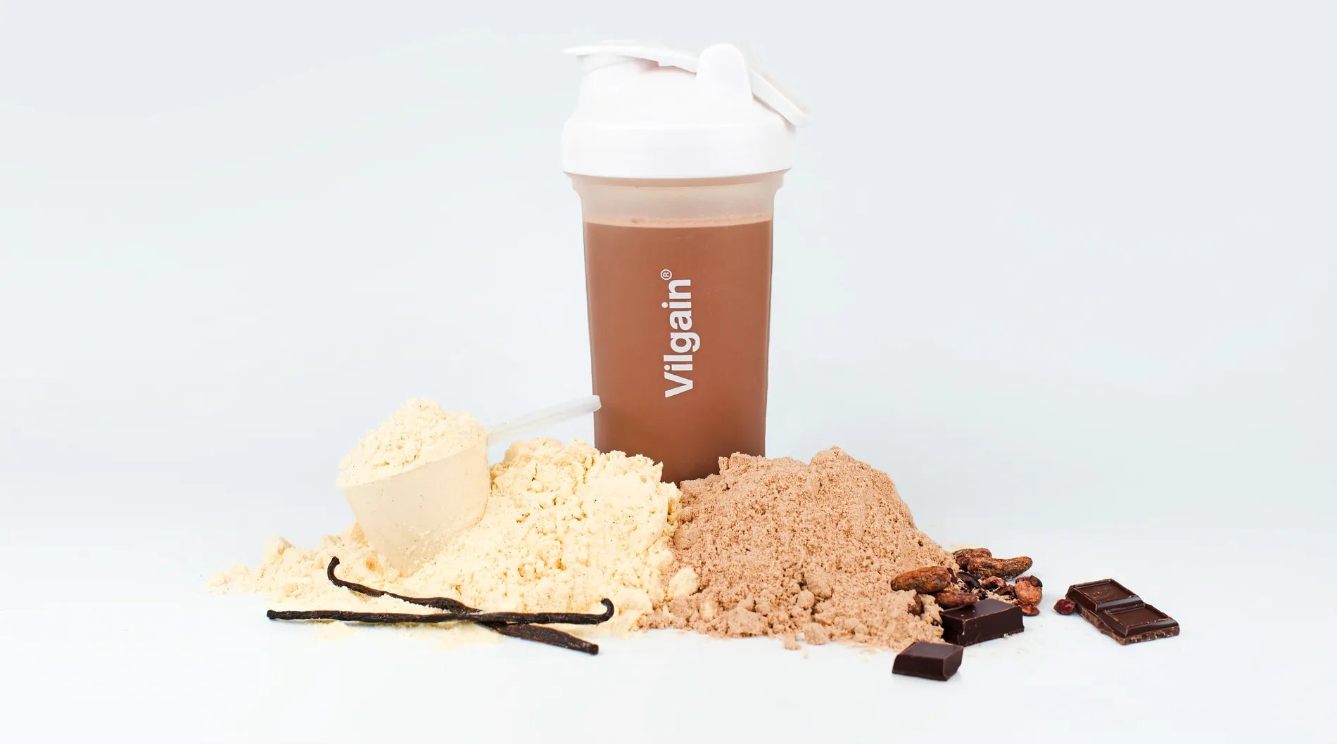 Lactose-Free Whey Protein in a shaker with protein powders and chocolate pieces on a white background.